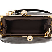Top-down view of a black crocodile-embossed handbag with a gold-tone kiss-lock frame and black satin lining, shown on a white background.