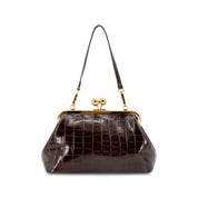 A CHOCOLATE BROWN crocodile-embossed handbag with a gold-tone kiss-lock frame and matching shoulder strap, shown on a plain white background.