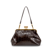A CHOCOLATE BROWN crocodile-embossed leather handbag with a gold-tone kiss-lock frame and shoulder strap, shown against a plain white background.