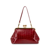 A Wine crocodile-embossed leather handbag with a gold-tone kiss-lock frame and a single shoulder strap, shown on a plain white background.