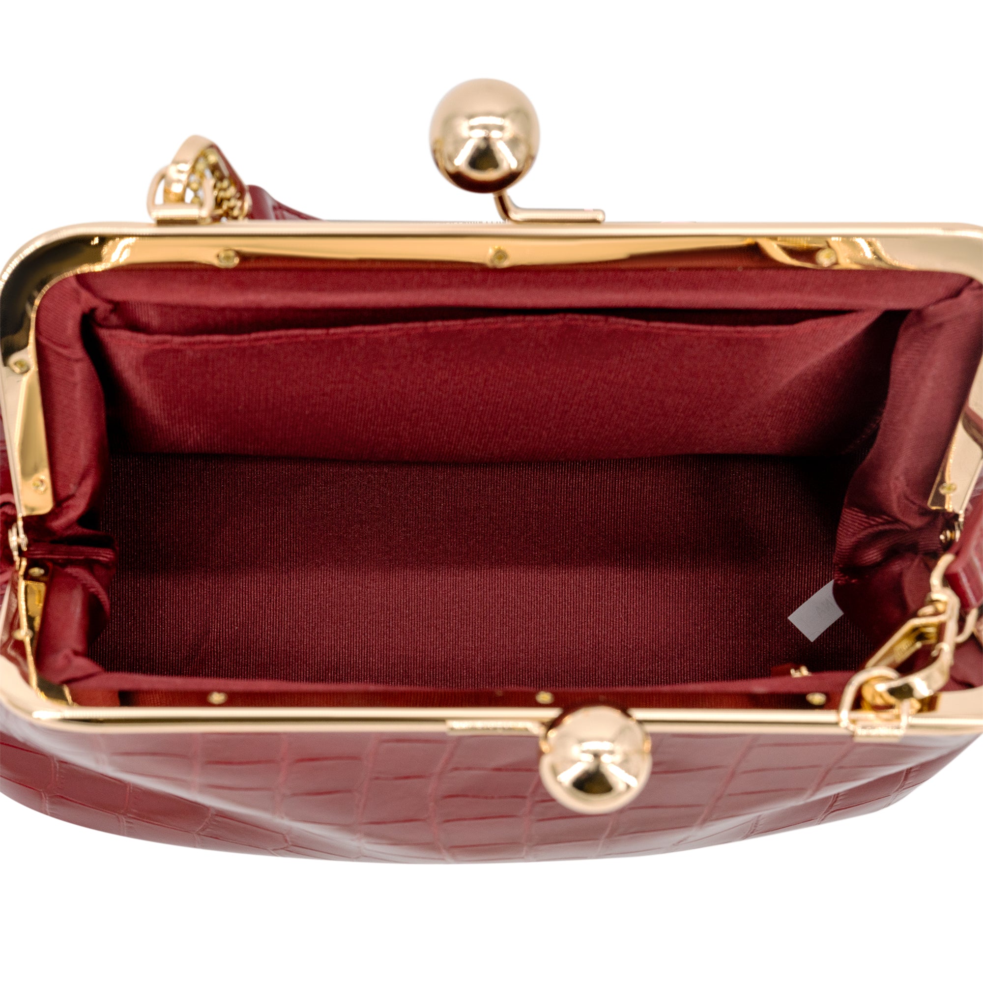 Close-up of the interior of a Wine crocodile-embossed handbag with a gold-tone kiss-lock frame and matching burgundy satin lining.