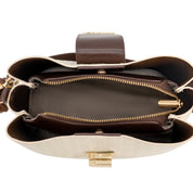 An overhead view of a structured handbag's open top, showing a cream-colored textured exterior, a dark brown interior lining, a brown leather strap, and gold-tone hardware including zippers and a clasp.