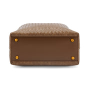 The bottom view of a brown woven leather handbag, showing a smooth brown leather base with four gold-tone metal studs, on a white background.