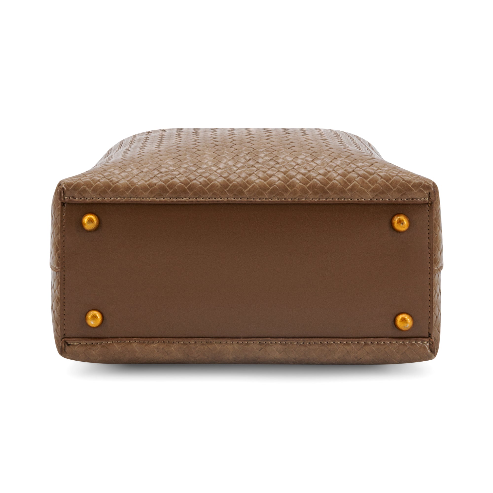 The bottom view of a brown woven leather handbag, showing a smooth brown leather base with four gold-tone metal studs, on a white background.
