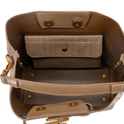 The interior of a taupe leather handbag shown from above, featuring a matching woven zippered pouch, gold-tone hardware, and a structured base.