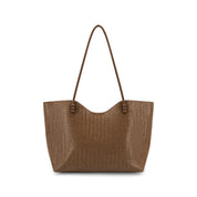 A brown woven leather tote bag with a slouchy, open top and two long shoulder straps, shown against a plain white background.