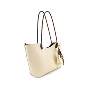 An Ivory textured leather tote bag with dark brown shoulder straps and a matching leather tassel charm, shown on a plain white background.